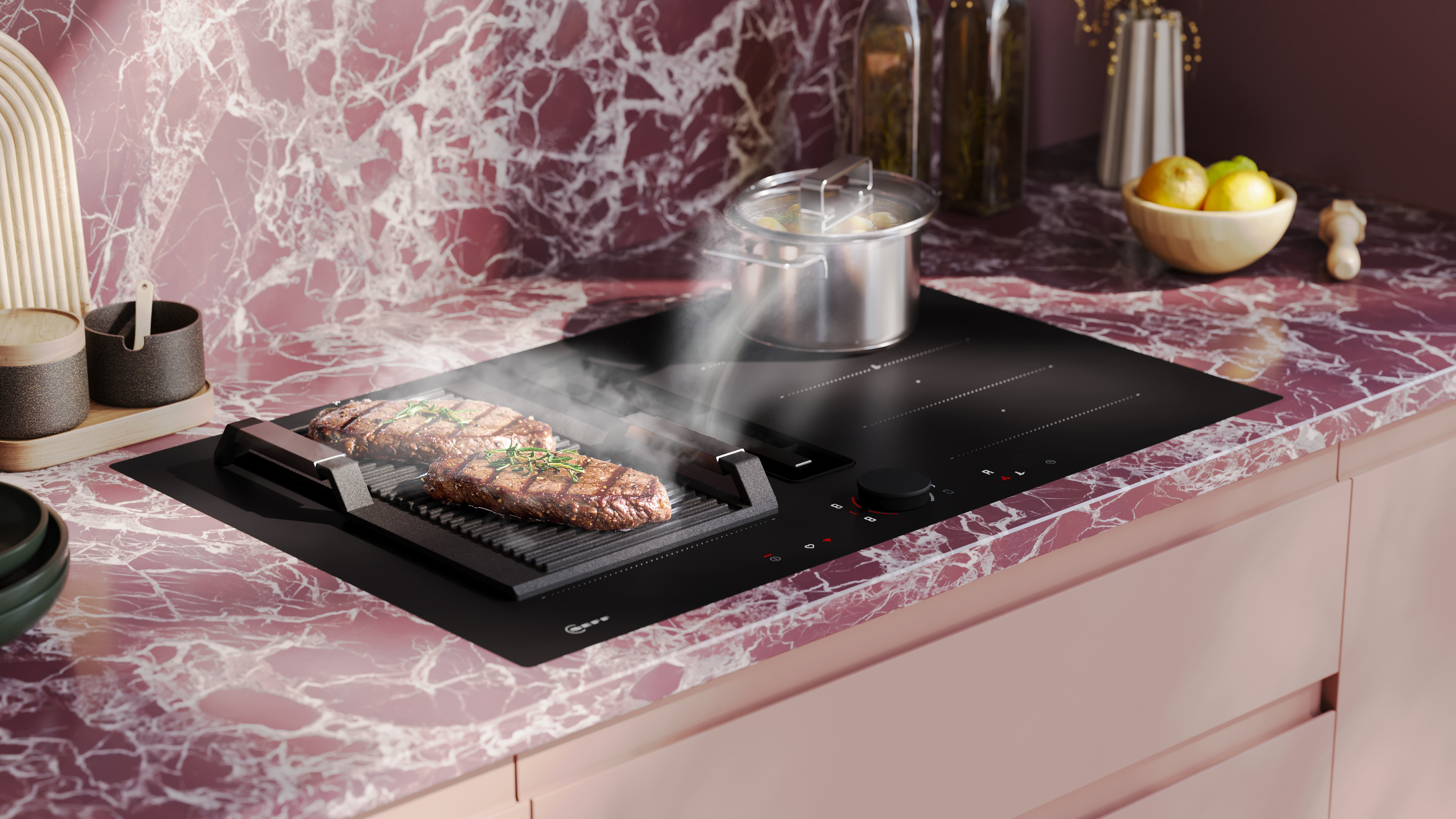 NEFF Collection Matt Black Design mattschwarzes Induktionskochfeld auf rosa marmorierter Arbeitsplatte Nischenrückwand gleich gestaltet