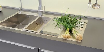 Küchenspüle aus hochwertigem Edelstahl, ergänzt durch genau passendes Schneidebrett und Abtropfbehälter