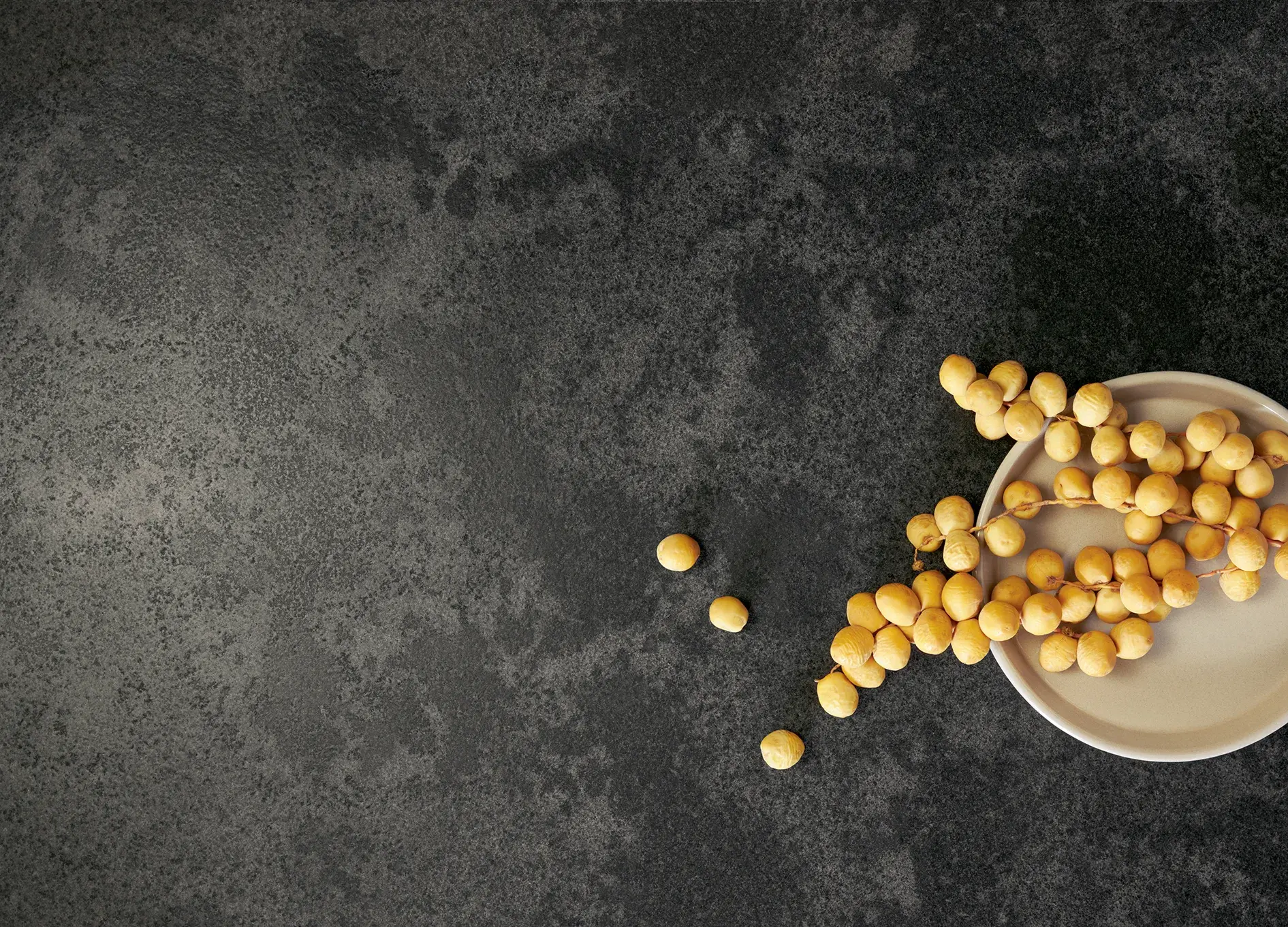 systemo dunkelgraue Naturstein APL darauf gelbe Barhi-Datteln 